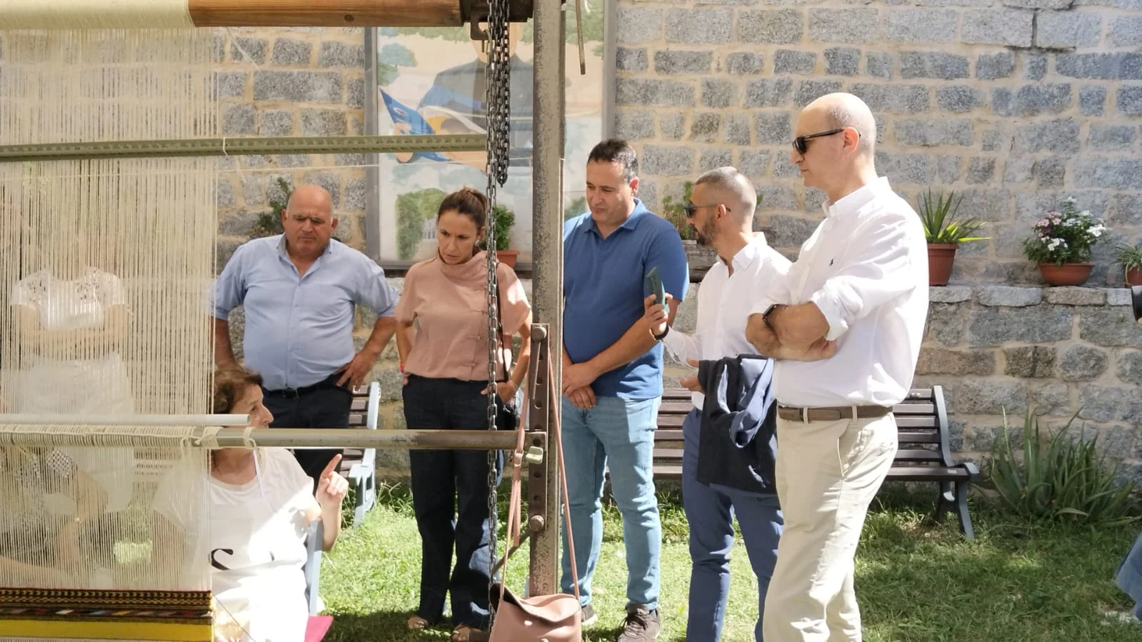 Tessitrice e partecipanti al gemellaggio accanto al telaio verticale
