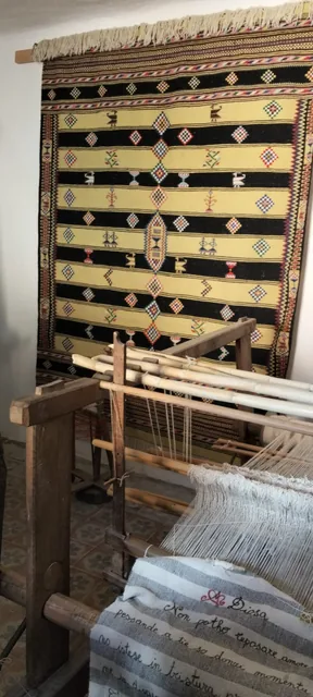 Un telaio e le trame tradizionali esposte.
